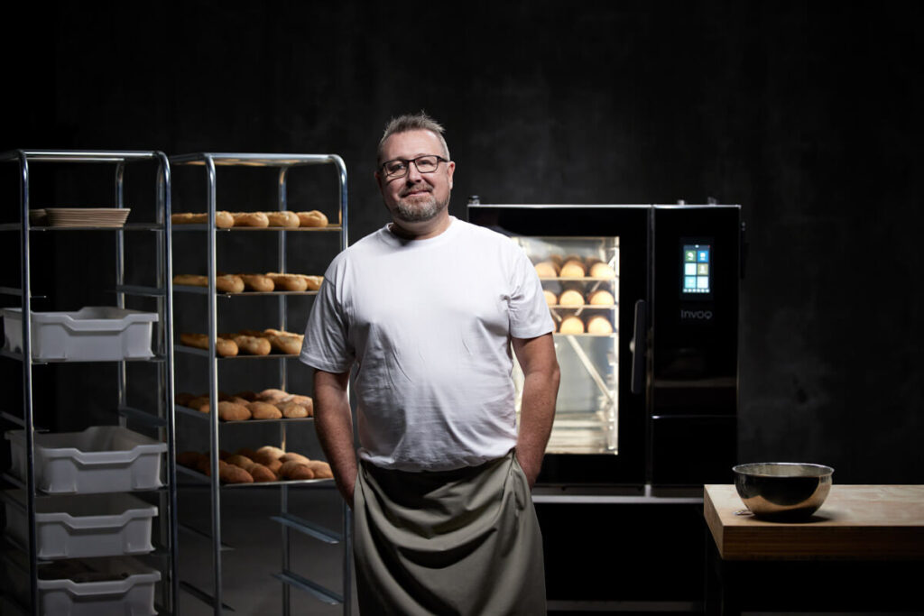 Professional baker working with bread and buns in an Invoq oven, ensuring uniform baking and high-quality results
